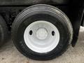A close-up of a Michelin tire mounted on a white wheel of a 2008 International 7500 truck with visible treads and rim bolts