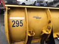 A yellow snowplow blade with the text Storm Guard and the number 295 visible on its side