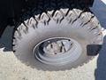 Close-up of a tire from a 2018 Kubota RTV-X 1100 C featuring an aggressive tread pattern and a metallic rim with five lug nut openings