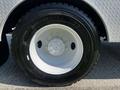 A close-up of a 2004 Freightliner M2 truck tire showing a chrome wheel rim and a black tire with visible tread and markings