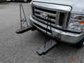 A 2013 Ford Econoline with a metal mounting system attached to the front for carrying additional equipment or accessories