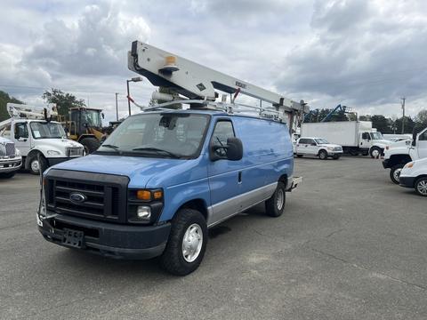 A blue 2010 Ford Econoline van with a raised utility bucket on top parked in a lot among other vehicles