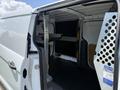 White 2021 Ford Transit Connect cargo van with open side door revealing an empty interior and shelving system installed on the walls