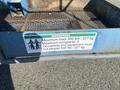 A blue instruction sign attached to a platform detailing maximum load capacity of 500 lbs and 2 occupants for a Genie S-65 4X4 lift machine