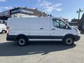 A white 2016 Ford Transit van with a sliding side door and two rear doors parked on a lot