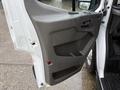 The image shows the driver's side door panel of a 2023 Ford Transit featuring a gray interior with a handle and controls for windows and locks