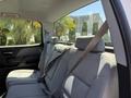 The interior of a 2016 GMC Sierra 1500 showing the back seat with gray fabric upholstery and a seatbelt secured on the middle seat