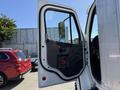 A 2015 Freightliner M2 106 with the driver's side door open showing the interior door panel and handle