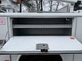A 2006 Ford F-450 truck is shown with an open storage compartment revealing a shelf inside for tools and equipment