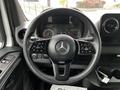The steering wheel of a 2019 Mercedes-Benz Sprinter featuring controls on the spokes and the Mercedes logo in the center