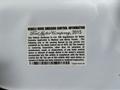 A 2016 Ford F-750 with a vehicle noise emission control information label attached to the body