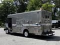 A silver 2008 Morgan Olson Workhorse delivery vehicle with large side compartments and a rear mounted step bumper