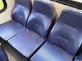 Three blue vinyl seats in a vehicle interior arranged side by side with a textured pattern