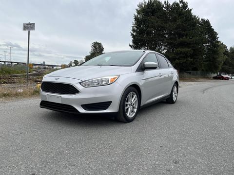 A silver 2018 Ford Focus parked on a gravel road with a sleek design and five-spoke wheels