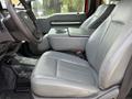 Interior view of a 2013 Ford F-550 showing gray leather seats with armrest and center console in the front cabin
