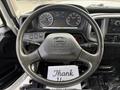 A 2017 Hino 338 truck's steering wheel and dashboard displaying speedometer and other gauges