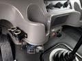 Close-up of the interior controls of a 2015 Freightliner M2 106 featuring dashboard switches a gear shifter and foot pedals