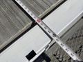 A 2023 Ford E-450 vehicle is parked with a measuring tape extended across a loading surface showing measurements on the tape