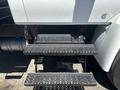 A 2018 International DuraStar featuring metal steps with perforated surfaces leading to the cab and a black battery compartment beneath the steps