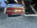 Close-up of a chrome footpeg on a motorcycle featuring red trim and the Harley-Davidson logo