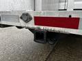 A close-up of the rear hitch receiver of a 2009 Ford Econoline showing metal textures and a red reflector on the trailer hitch