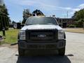 A white 2012 Ford F-450 Super Duty truck with an elevated cab view and yellow lights on the roof