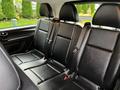 Interior view of the rear seating area of a 2018 Mercedes-Benz Metris with three black leather seats and seatbelts mounted on the backrest