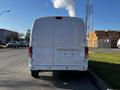 A 2017 Nissan NV200 van viewed from the rear with a blank license plate area and visible exhaust smoke rising from the vehicle