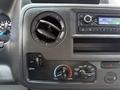 Control panel of a 2022 Ford Econoline featuring air conditioning and ventilation knobs along with a radio display showing the time and frequency