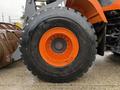 A large tire of a 2018 Doosan DL300-5 wheel loader featuring a black rubber tread and an orange rim with multiple bolt holes