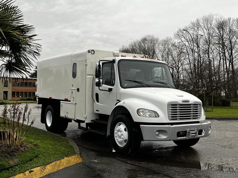 A white 2007 Freightliner M2 106 truck with a boxy cargo area and large tires parked on a paved surface