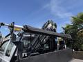 A 2012 Ford F-450 SD with a mounted crane arm positioned at the rear of the truck