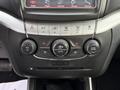 Dash controls of a 2013 Dodge Journey featuring climate control knobs and display screen with radio and vehicle settings