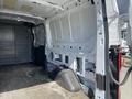 Interior view of a 2019 Ford Transit cargo van showing the empty rear space with unpainted walls and a raised floor section