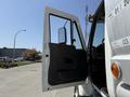 A 2009 International 7500 truck with its front driver's side door open, revealing the interior and driver's seat