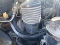 Close-up of the engine compartment of a 2014 International 7400 featuring rubber hoses and a cylindrical air intake connected to various engine components