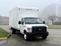 A white 2019 Ford Econoline box truck parked on a road with a large enclosed cargo area and front cab featuring a black grille and headlights