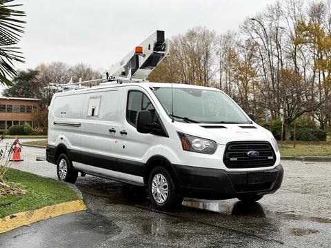 2019 Ford Transit van with a white exterior featuring a service body and ladder rack mounted on the roof