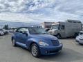 A blue 2007 Chrysler PT Cruiser convertible parked with a black soft top and chrome wheels