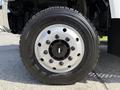 Close-up of a wheel on a 2009 GMC C5500 featuring a shiny chrome rim with multiple lug nut holes and a rugged black tire tread