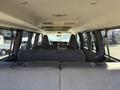 Interior view of a 2021 Chevrolet Express van showing the rear seating arrangement with two rows of seats facing forward