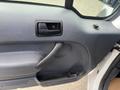 Interior door panel of a 2010 Ford Transit Connect featuring a black handle speaker grille and a textured surface