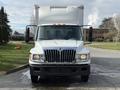 A white 2014 International TerraStar truck with a boxy cargo area and prominent front grille is facing the camera with its doors open