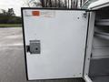 A white door of a refrigerated truck with a secure latch and interior shelving visible