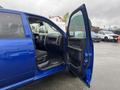 A blue 2019 RAM 1500 Classic with the driver's door open displaying the interior features including seats and dashboard