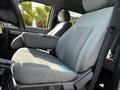 A spacious grey fabric seat of a 2016 Ford F-550 showing a comfortable armrest and ergonomic design