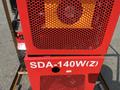 Close-up of a red industrial machine with a perforated grill and the label SDA-140W(Z) prominently displayed on the front