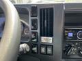 The dashboard of a 2016 Isuzu NPR featuring various controls including air conditioning vents and a digital display with on-off buttons for the body and other functions