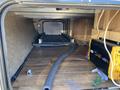Inside a 2016 Jayco 265RLSW trailer featuring a clean wood floor and storage compartments with a black and yellow power inverter visible