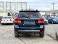A 2013 Dodge Journey viewed from the rear with a dark blue exterior and a distinctive taillight design
